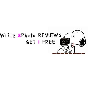 May include: A black and white cartoon illustration of Snoopy holding a camera. Text above reads "Write 2 Photo Reviews Get 1 Free". The image is on a white background.