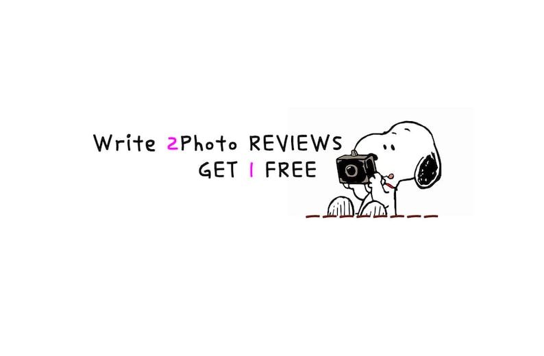 May include: A black and white cartoon illustration of Snoopy holding a camera. Text above reads "Write 2 Photo Reviews Get 1 Free". The image is on a white background.