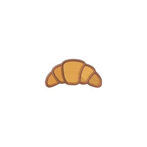 May include: An embroidered patch of a croissant featuring golden yellow thread for the pastry layers and dark brown thread for the outlines and shading. The design shows the curved, crescent shape of the baked good with visible stitching texture.