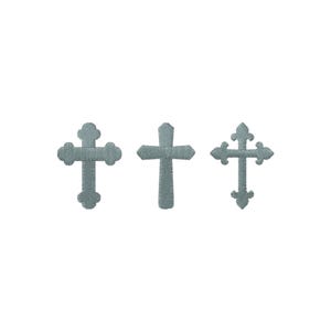 May include: Three embroidered crosses in a soft, muted teal color. Each cross has a unique design, with varying arm shapes and decorative elements. The crosses are set against a plain white background.