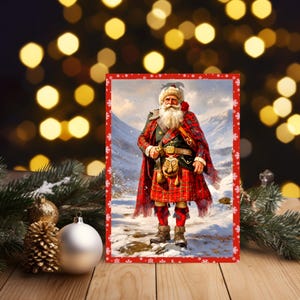 K&ouml;nnte beinhalten: Eine rechteckige Weihnachtskarte mit einer zentralen Illustration einer b&auml;rtigen Figur, die einen rot-gr&uuml;n karierten Kilt, einen passenden Tartan-Schal, einen Sporran und braune Stiefel tr&auml;gt, vor einer verschneiten Berglandschaft mit einem roten Schneeflockenrand.
