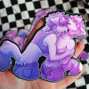May include: A sticker featuring two purple and pink furry characters hugging each other. The characters are wearing jeans and have a soft, dreamy look.
