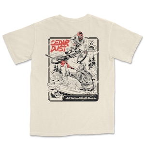 May include: A beige t-shirt with a graphic print of a mountain biker flying through the air with a chainsaw. The graphic is in black and white with red accents. The text "CEDAR DUST" is in red and the text "a Tall Tale from Galbraith Mountain" is in black.