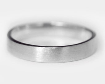 May include: A simple silver wedding band with a brushed finish.