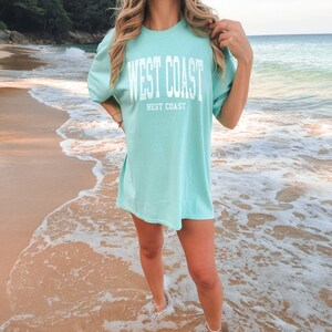 a woman wearing a west coast best coast tee in chalky mint