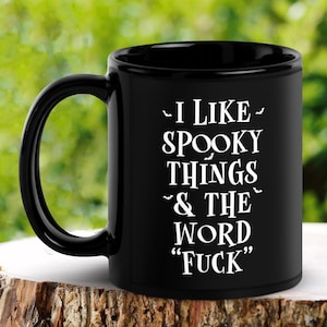 May include: Black coffee mug with white text that reads "I like spooky things & the word "F*ck""