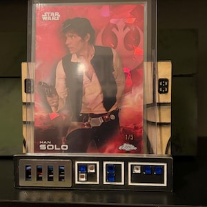 May include: A set of three ceramic mugs with a speckled, matte finish. The mugs are in shades of cream, light gray, and dark gray. Each mug has a simple, minimalist design, perfect for coffee or tea.