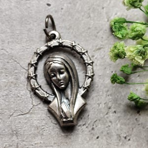 religious medal of a young girl praying in silver color