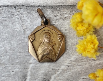 Zeldzame antieke religieuze medaille van de heilige Thérèse van Lisieux in goudkleur.