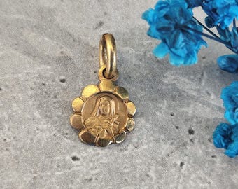 Antieke religieuze medaille van de heilige Thérèse van Lisieux in de vorm van een bloem, verguld.