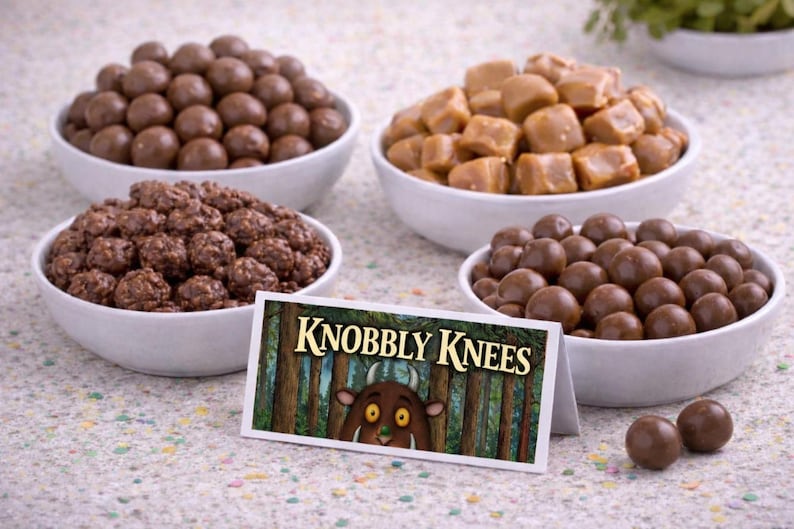May include: Four white bowls filled with different candies: chocolate malt balls, caramel cubes, and chocolate-covered clusters. A sign reads "Knobbly Knees" with a forest illustration and a cartoon character.