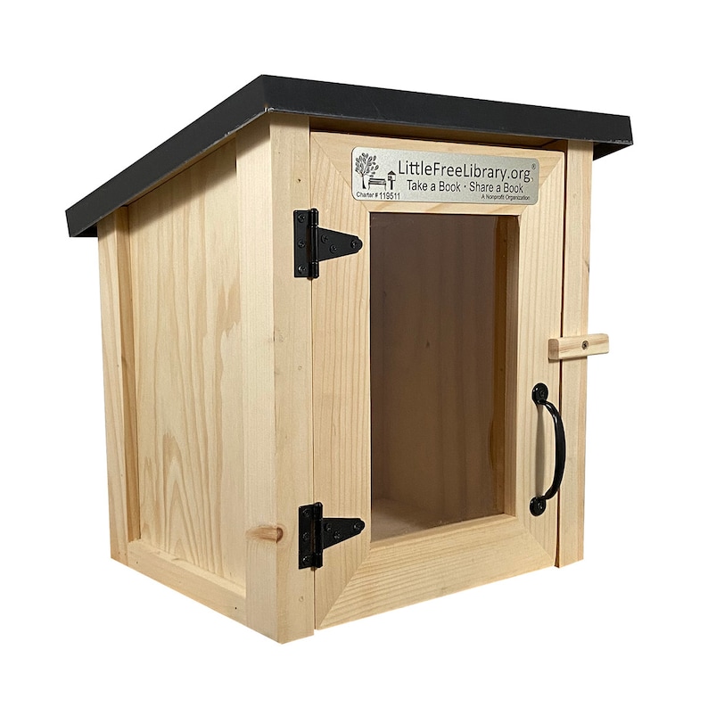 May include: A wooden Little Free Library with a black roof and a glass door. The library has a sign that says "LittleFreeLibrary.org Take a Book - Share a Book A Nonprofit Organization" and "Charter #11611".