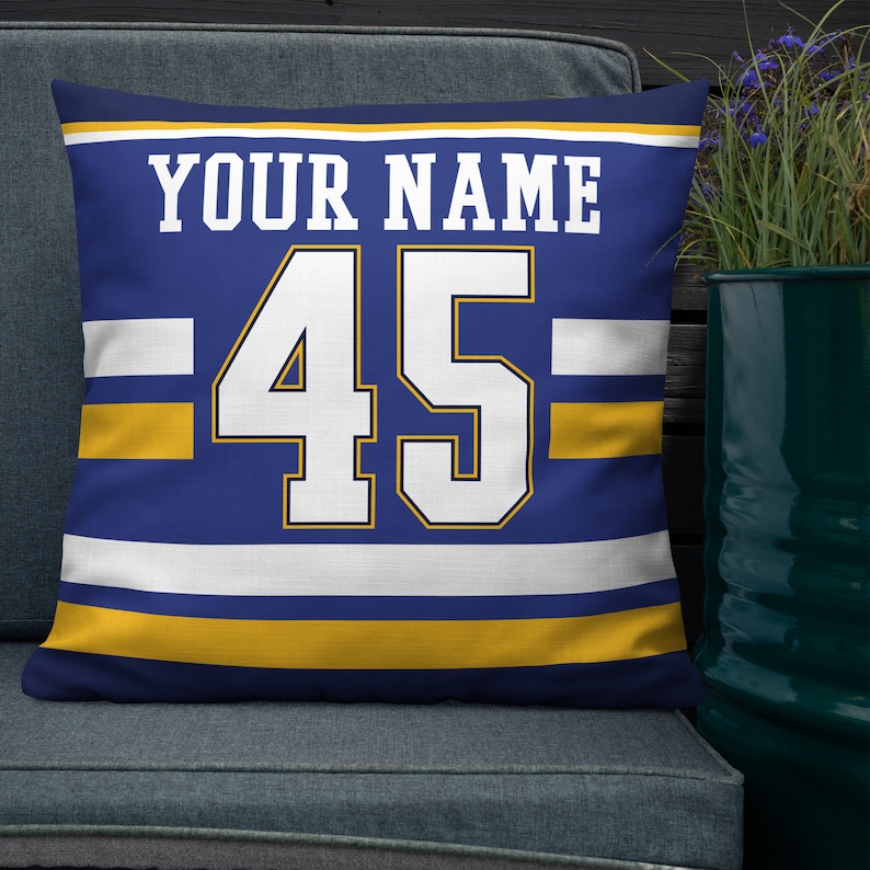 May include: A blue and gold throw pillow with white stripes and the text "YOUR NAME" and the number "45" in white.