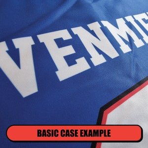 May include: Close-up of a blue jersey with the word "VENM" printed in white.