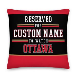 May include: Red and black pillow with gold accents. The pillow has the text "RESERVED FOR CUSTOM NAME TO WATCH OTTAWA" on it.