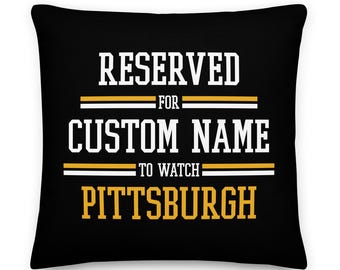 May include: Black throw pillow with white text that reads "RESERVED FOR CUSTOM NAME TO WATCH PITTSBURGH". The text is outlined in yellow.
