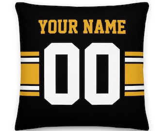May include: Black and gold decorative pillow with a white jersey number "00" and the text "YOUR NAME" printed on it.