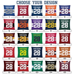 Könnte beinhalten: Ein Raster aus fünfundzwanzig quadratischen Kissendesigns, nummeriert von 1 bis 25, die jeweils den Text YOUR NAME über der Zahl 28 in verschiedenen Farbkombinationen und Streifenmustern unter der Überschrift CHOOSE YOUR DESIGN zeigen.