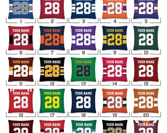 May include: A grid of twenty-five square pillow designs labeled 1 through 25, each featuring the text YOUR NAME above the number 28 in various color combinations and stripe patterns, all under the heading CHOOSE YOUR DESIGN.