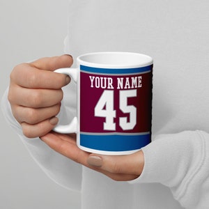 May include: White ceramic mug with a burgundy, gray, and blue design. The mug has the text "YOUR NAME" and the number "45" in white.