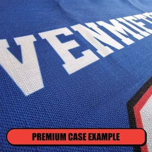 May include: Close-up of a blue fabric with the word "VENICE" printed in white. The fabric has a textured, woven appearance.