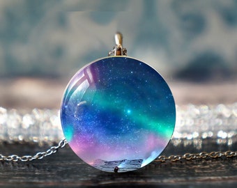 May include: A silver chain necklace with a round glass pendant featuring a colorful aurora borealis scene with stars.