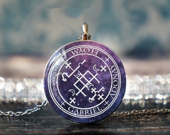 May include: A silver pendant necklace with a round, glass charm featuring a white sigil on a purple and black galaxy background. The sigil is surrounded by the text "Elohim Tetragrammaton + Gabriel + Adonai".
