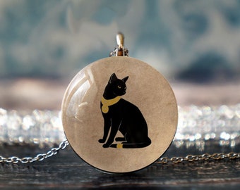 May include: A silver chain necklace with a round glass pendant featuring a black cat with a gold collar. The cat is sitting with its tail curled around its legs.