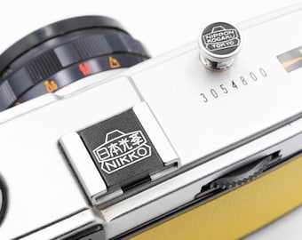 Anpassat graverat Nikon-skydd och slutarknapp: Unikt kameratillbehör