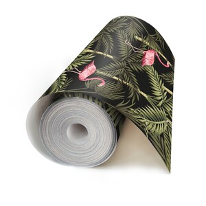 May include: A roll of black and green wallpaper with a tropical leaf pattern and pink flamingos.
