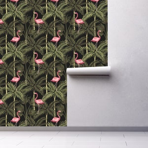 May include: A black and green tropical wallpaper featuring pink flamingos standing in palm trees. The wallpaper is shown partially unrolled on a white wall.