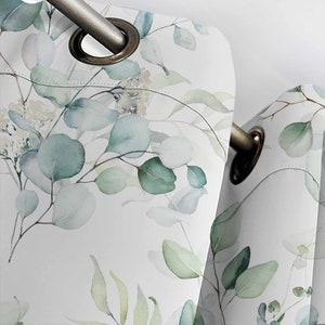 May include: White curtains with a watercolor pattern of green eucalyptus leaves. The curtains have grommets for hanging.