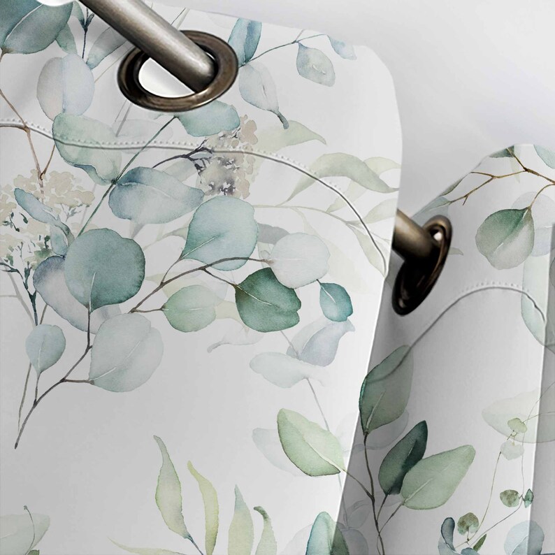 May include: White curtains with a watercolor pattern of green eucalyptus leaves. The curtains have grommets for hanging.