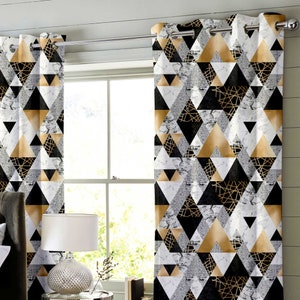 May include: A pair of black, gold, and white geometric patterned curtains with silver grommets. The curtains feature a repeating pattern of triangles with a marble-like texture.