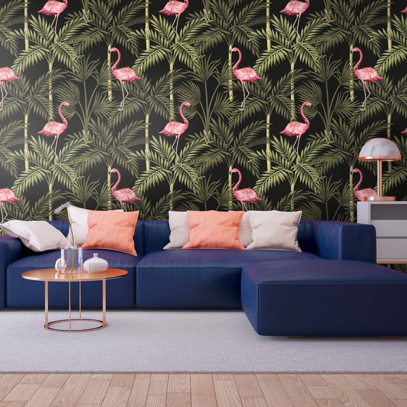 May include: A navy blue sectional sofa with a light gray rug in front of it. The wall behind the sofa is covered in black wallpaper with a repeating pattern of pink flamingos and green palm leaves.