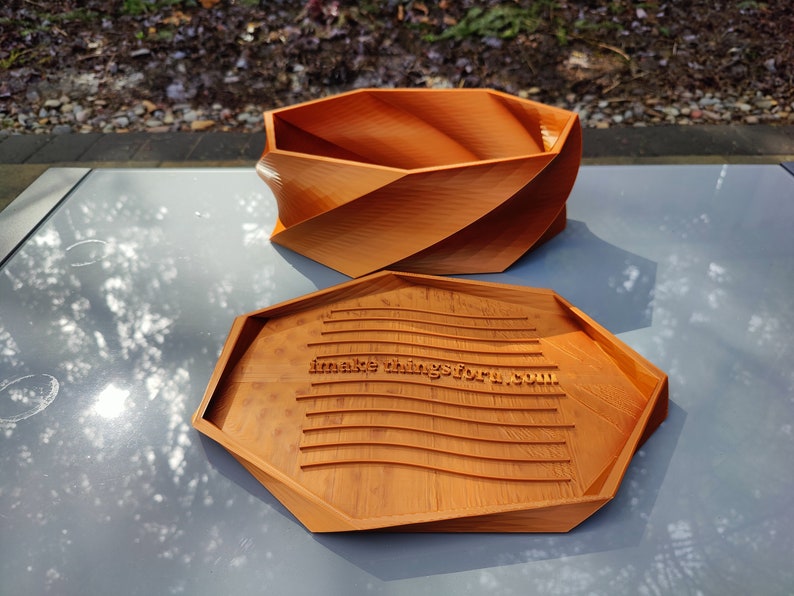 May include: A wooden, octagonal box with a lid. The lid has a wavy, textured surface with the text "makethingsforu.com" engraved on it.