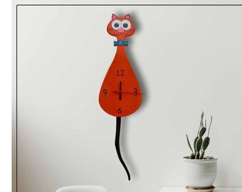 Puede incluir: Reloj de pared de color naranja con forma de gato, con agujas negras y una pajarita azul. El reloj tiene un fondo blanco con números negros.