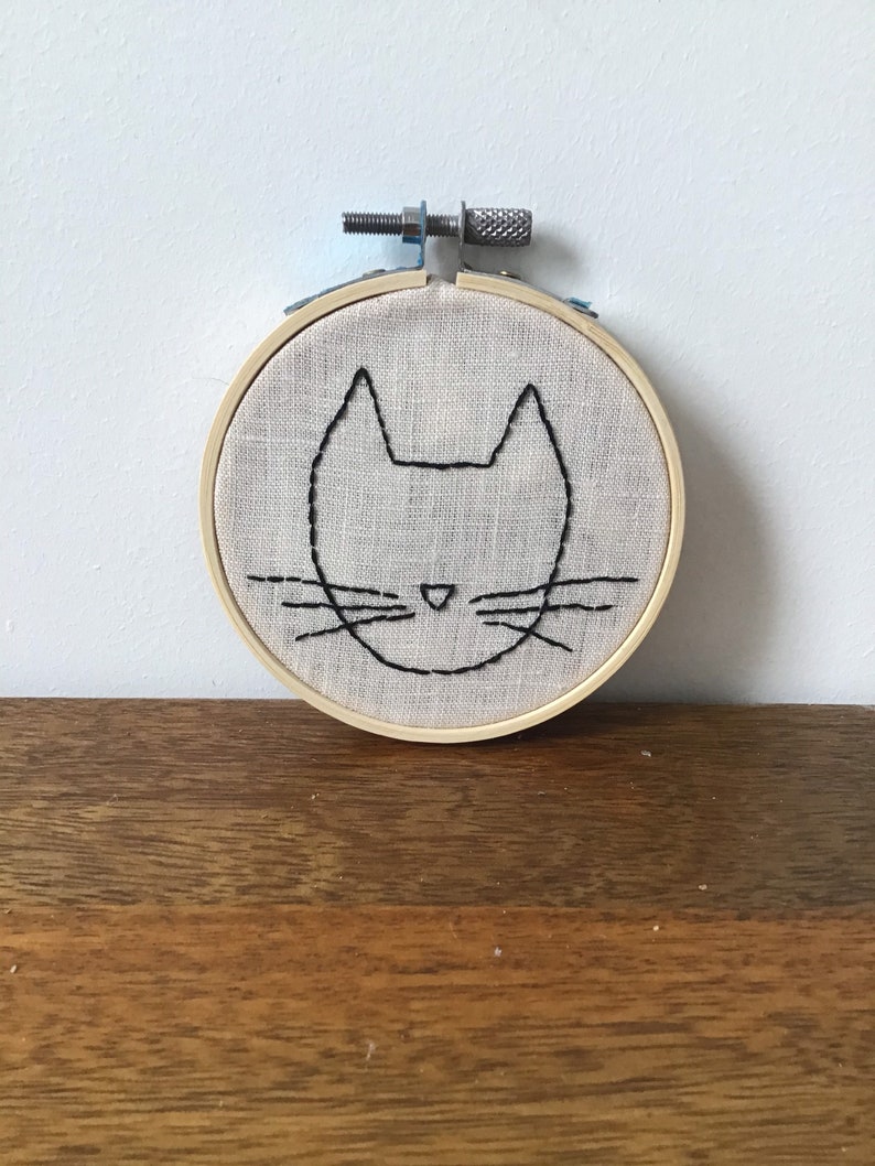 Hand embroidery of a minimalist cat head