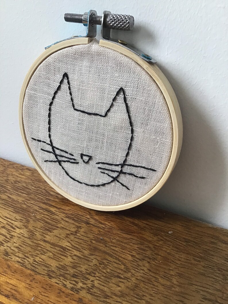 Hand embroidery of a minimalist cat head