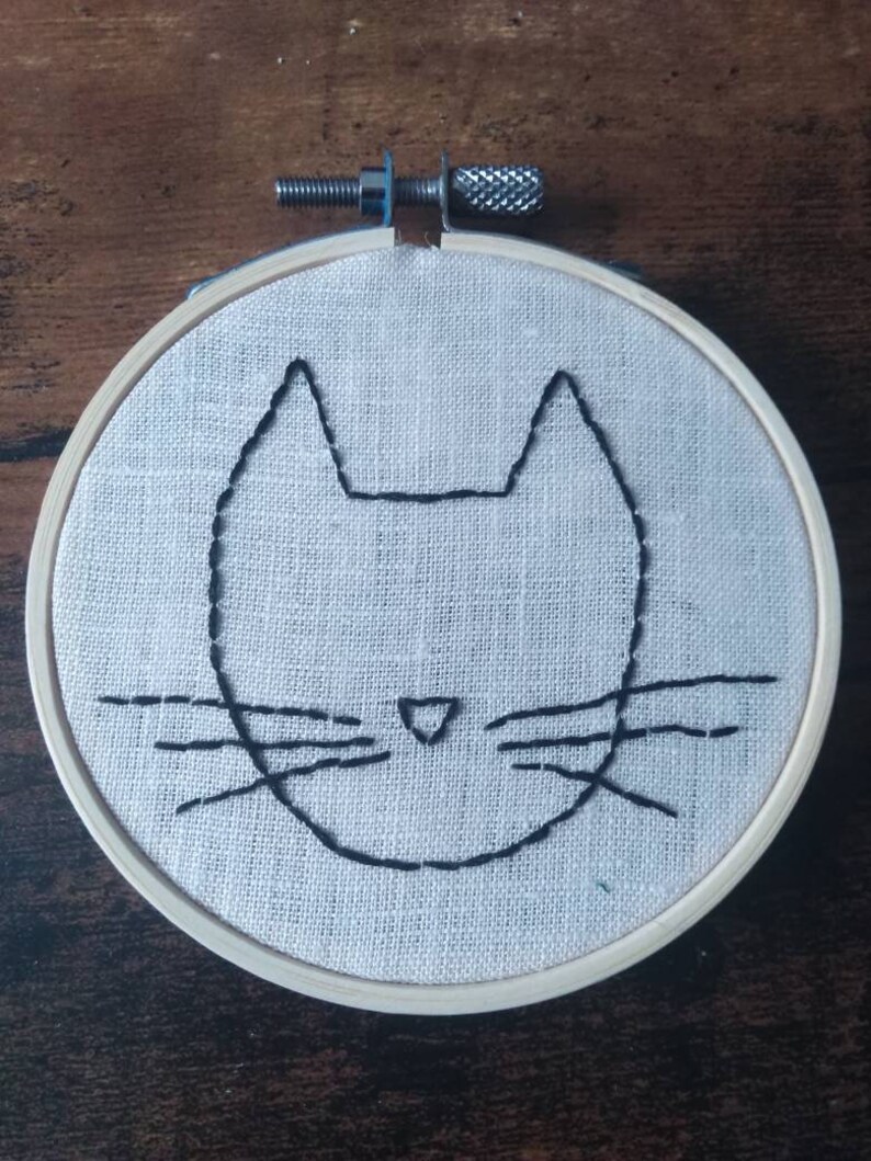 Hand embroidery of a minimalist cat head
