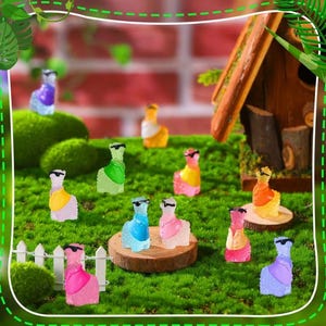 May include: A collection of miniature llama figurines in various colors, including pink, blue, green, and yellow, each wearing sunglasses. The llamas are arranged on a bed of green moss, with a small wooden birdhouse in the background.