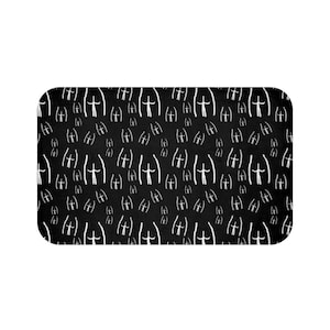 May include: Black bath mat with a white repeating pattern of stick figures with arms raised.