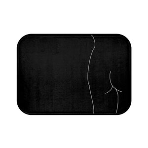 May include: Black bath mat with a white line drawing of a person's back and hips.