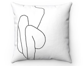 May include: A white throw pillow with a black line drawing of a person sitting with their legs crossed.