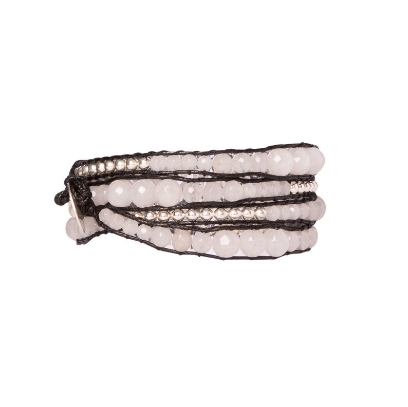 K&ouml;nnte beinhalten: Ein mehrreihiges Armband mit wei&szlig;en Perlen und silbernen Akzenten auf einem schwarzen Band.