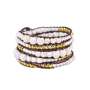May include: A multi-strand bracelet with white and gold beads wrapped around a brown cord.
