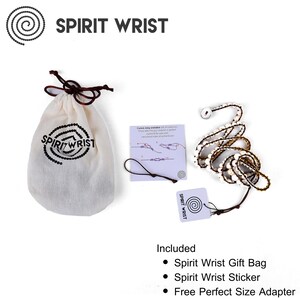 May include: A white and brown beaded bracelet with a gold accent, a white drawstring bag with the text "Spirit Wrist" printed on it, a white card with the text "Spirit Wrist" and a spiral design, and a white card with instructions for adjusting the bracelet.