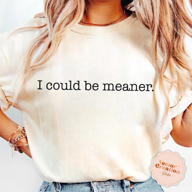 Puede incluir: Una camiseta blanca con el texto "I could be meaner." impreso en negro.
