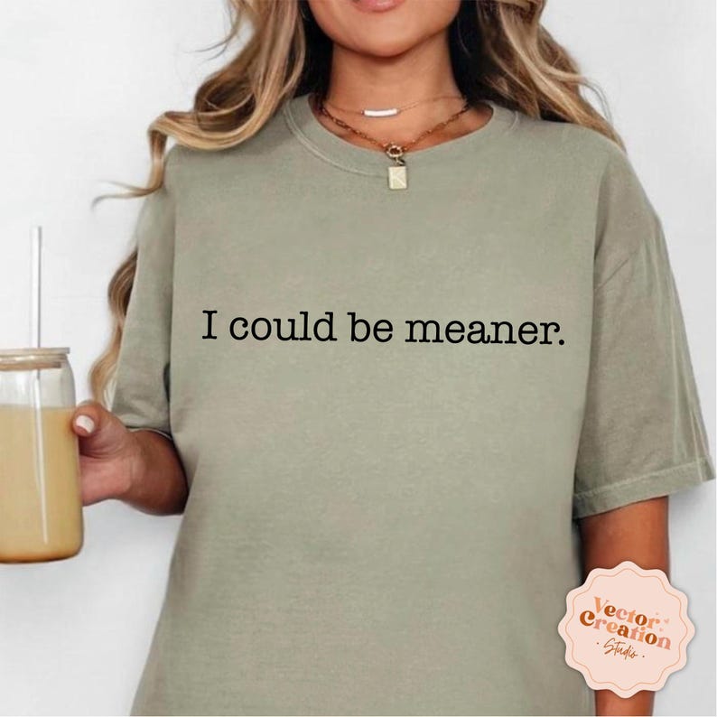 Puede incluir: Una camiseta verde claro con el texto "I could be meaner." impreso en negro.