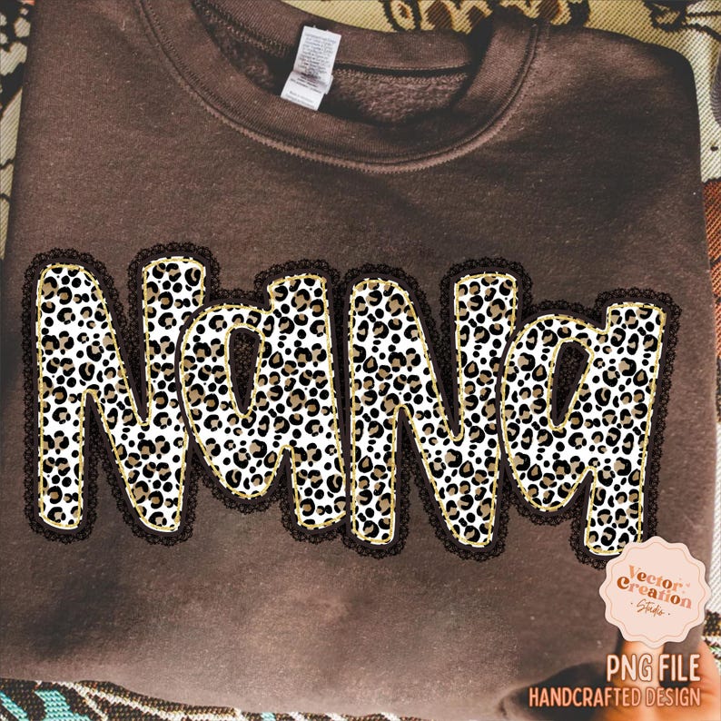 May include: A brown sweatshirt with the word "Nana" in a leopard print design. The letters are outlined in gold and framed with a black lace trim. The bottom right corner features a logo that says "PNG File Handcrafted Design".